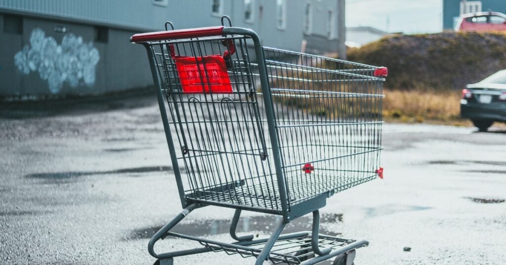 Shopping cart sitting in an empty parking lot.