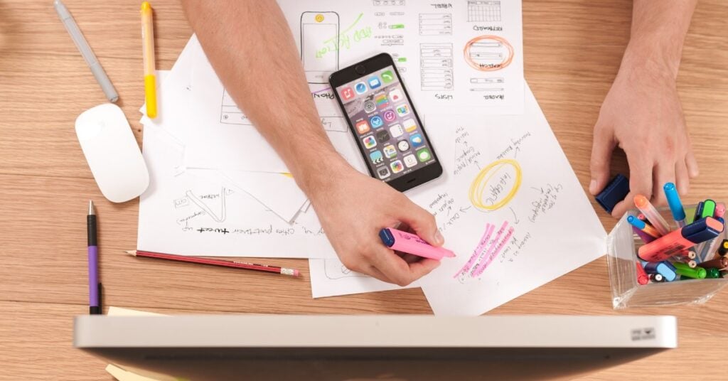 Man highlighting market research data at a desk.