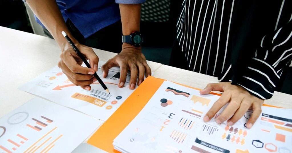 Two people defining their market research process at a desk.