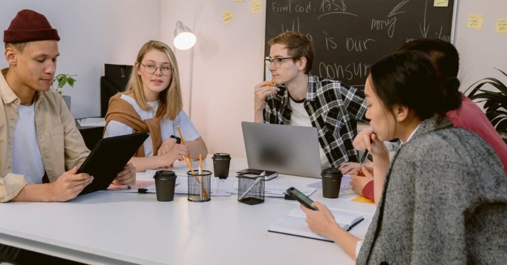 Five people around a conference table discussing ways to validate a business idea.